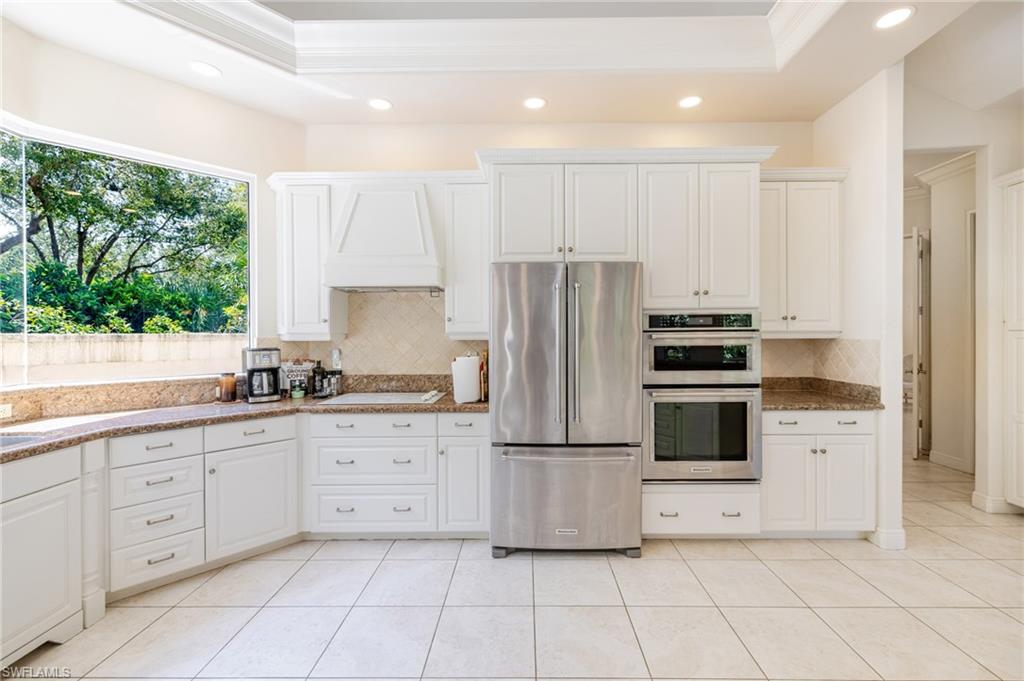 20481 Chapel Trace Estero, FL 33928 - Photo 9 of 50 a kitchen with white cabinets a refrigerator and a stove