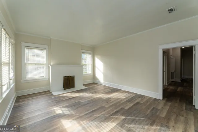 an empty room with windows fireplace and windows