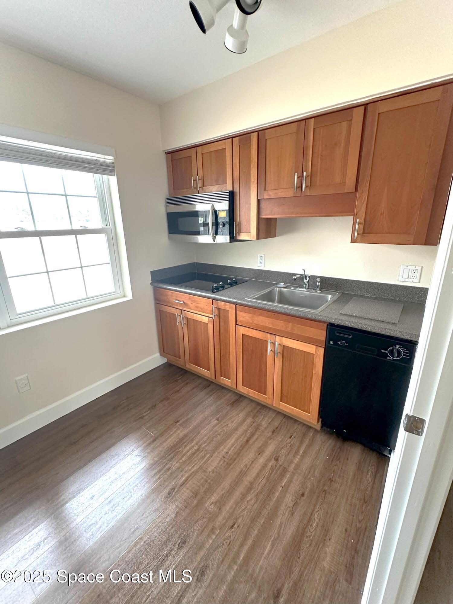 202 4th Avenue Indialantic, FL 32903 - Photo 4 of 6 a kitchen with stainless steel appliances granite countertop a stove a sink and a microwave