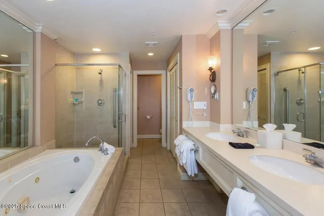 a bathroom with a tub a double vanity sink and mirror