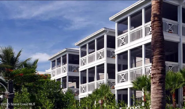 a front view of a building with a yard and plants