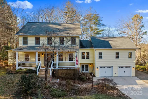 a view of a white house with large windows and a small yard