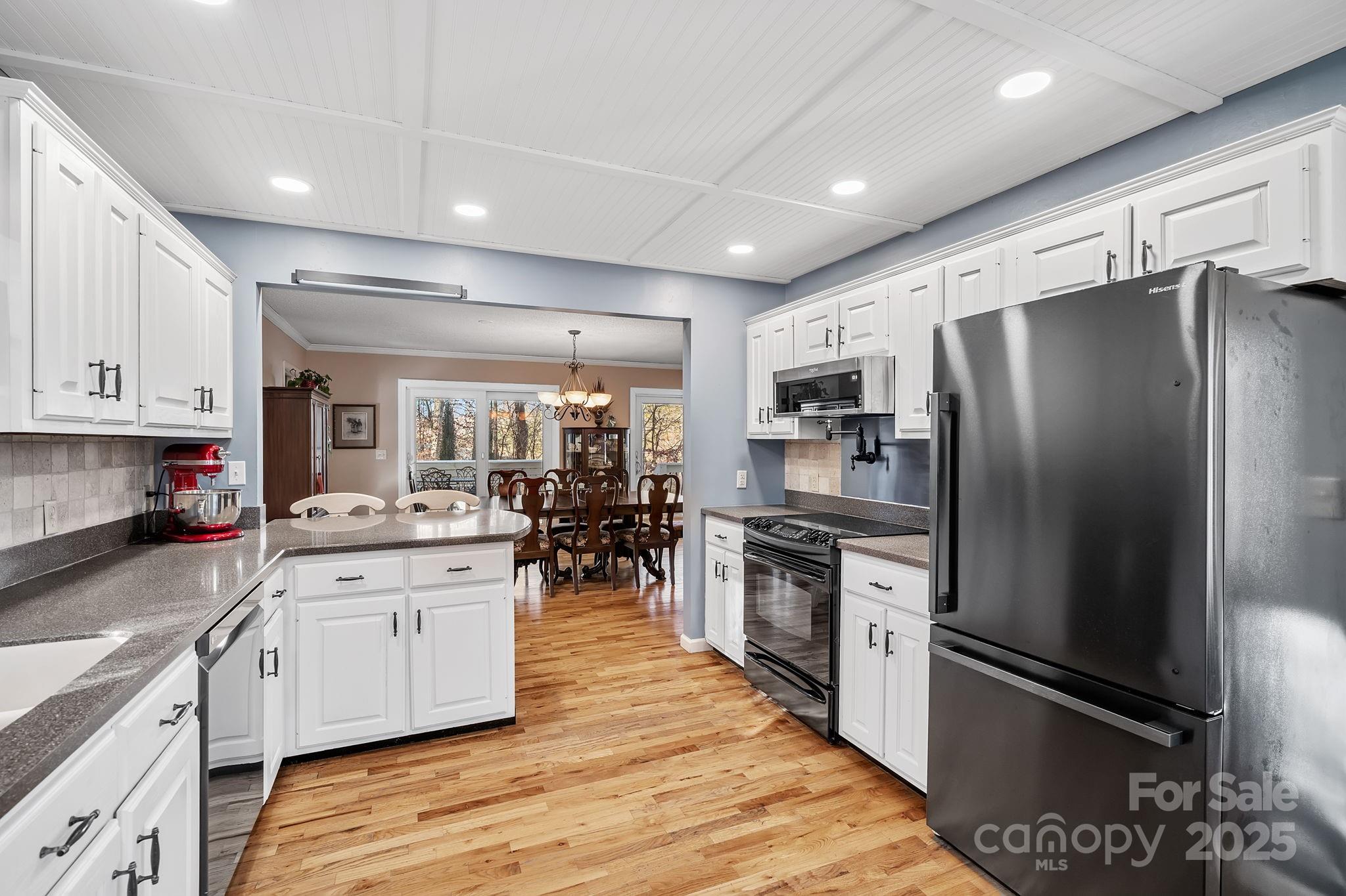 22 Sunset Lane Alexander, NC 28701 - Photo 11 of 48 a kitchen with stainless steel appliances kitchen island granite countertop a refrigerator oven a sink dishwasher and white cabinets with wooden floor