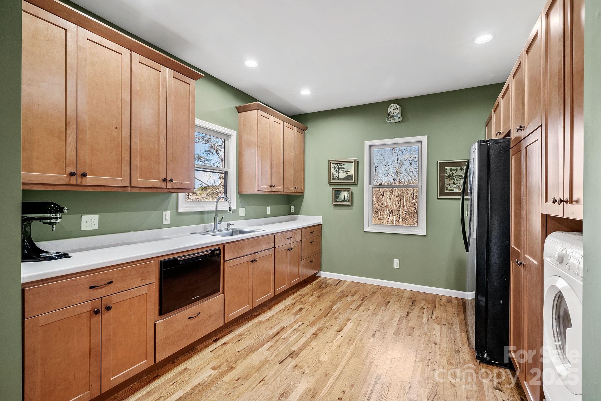 22 Sunset Lane Alexander, NC 28701 - Photo 26 of 48 a kitchen with stainless steel appliances granite countertop a refrigerator a sink dishwasher and wooden cabinets with wooden floor