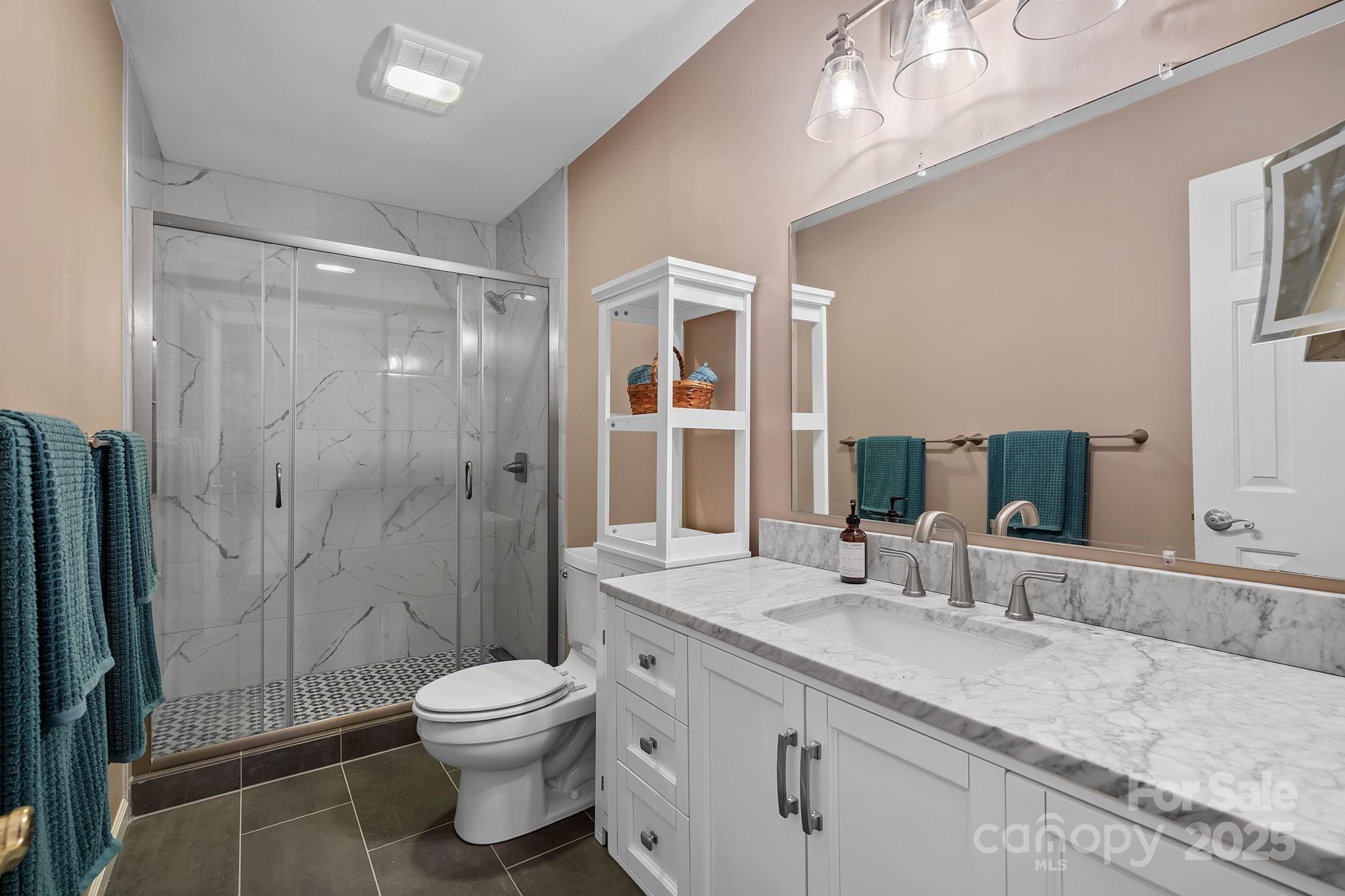 22 Sunset Lane Alexander, NC 28701 - Photo 37 of 48 a bathroom with a granite countertop sink toilet a large mirror a shower and vanity