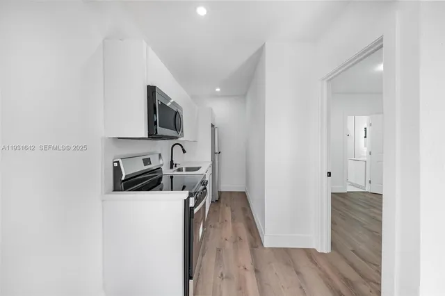 a kitchen with a refrigerator and a stove top oven