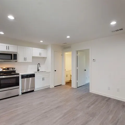 a large kitchen with stainless steel appliances granite countertop a stove a sink and a refrigerator