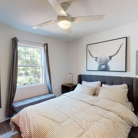 a bedroom with a bed and a painting on the wall