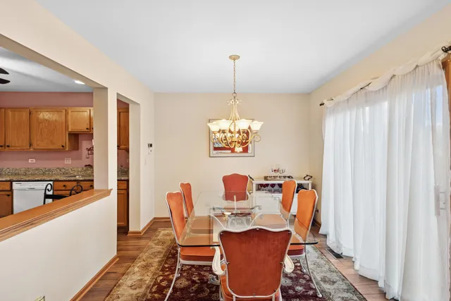 a dining room with furniture a chandelier and wooden floor