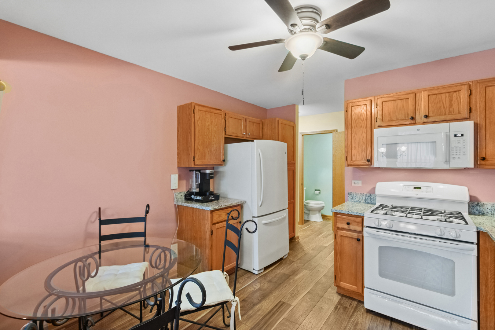 18 Peach Tree Court Algonquin, IL 60102 - Photo 10 of 23 a kitchen with stainless steel appliances a stove a refrigerator a dining table and chairs with wooden floor