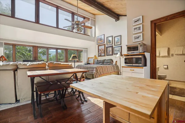 a dining room with stainless steel appliances a table and chairs