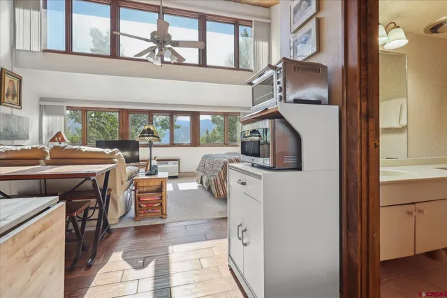 a living room with furniture a flat screen tv and a window