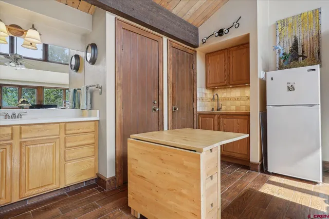 a kitchen with a refrigerator a stove cabinets and wooden floor