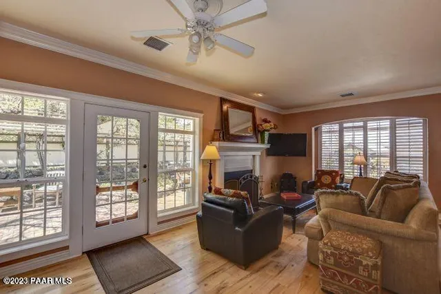 a living room with furniture fireplace and a large window