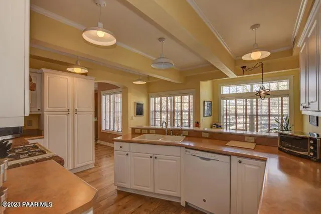 a large kitchen with kitchen island granite countertop a large window and a sink