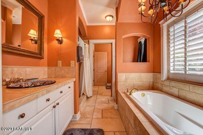 325 East E Union Prescott, AZ 86303 - Photo 8 of 11 a bathroom with a granite countertop tub a sink and a large mirror next to a window