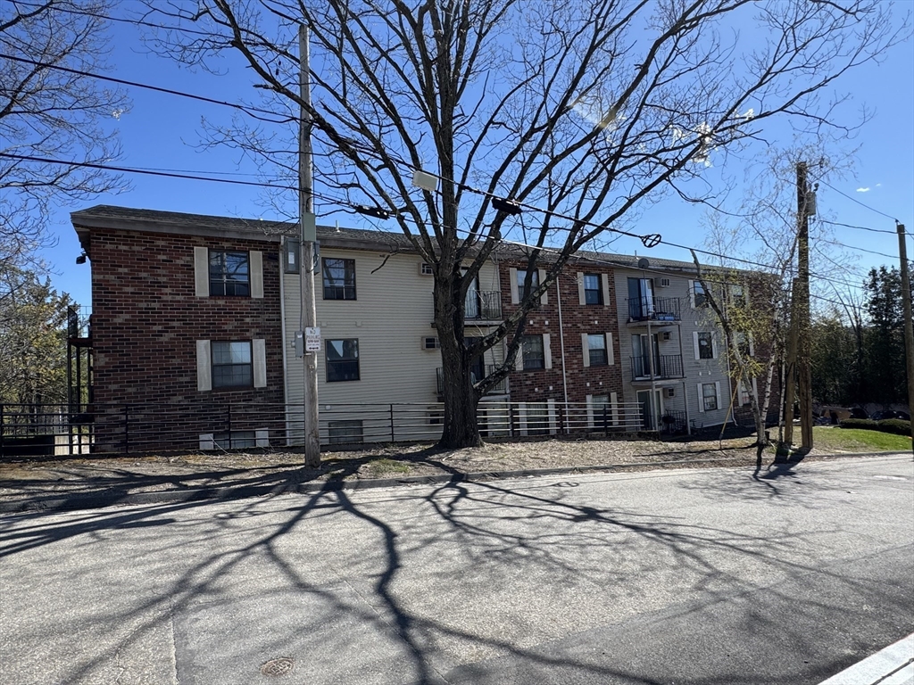 10 Hemans Street, Unit 21 Worcester, MA 01605 - Photo 3 of 4 a front view of a building with a yard