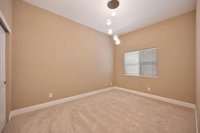 an empty room with a ceiling fan and a window