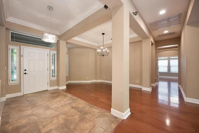 a view of a hallway with wooden floor and windows