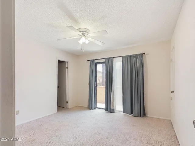 an empty room with closet and a ceiling fan