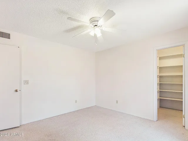 a view of an empty room with a ceiling fan