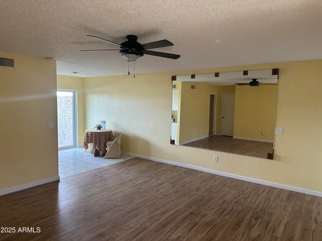 a view of a livingroom with wooden floor and a ceiling fan