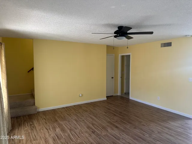 an empty room with wooden floor a ceiling fan and closet