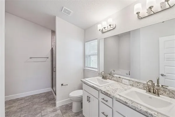 a bathroom with a granite countertop sink a toilet and a mirror