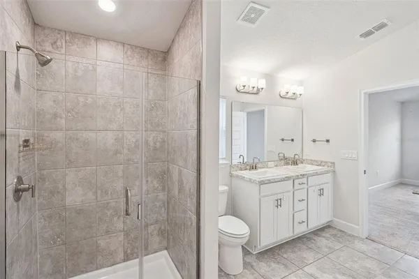 a bathroom with a granite countertop sink toilet a mirror and shower