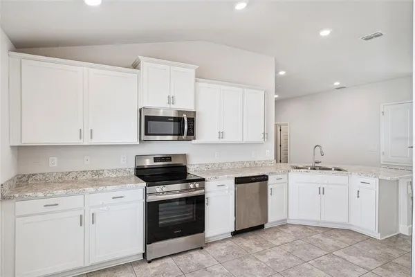 a kitchen with white cabinets stainless steel appliances and sink