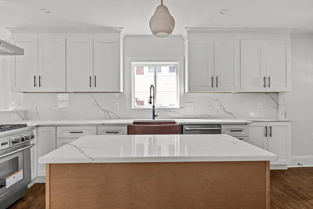 a kitchen with a sink a stove and cabinets