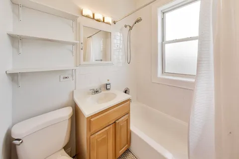a bathroom with a sink toilet vanity and tub