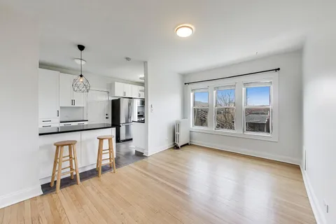 a kitchen with stainless steel appliances kitchen island hardwood floor sink stove and wooden cabinets