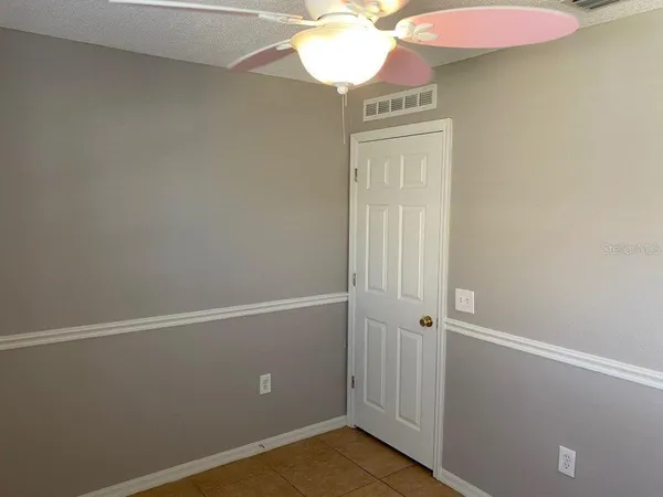 a view of a small space with wooden floor and fan