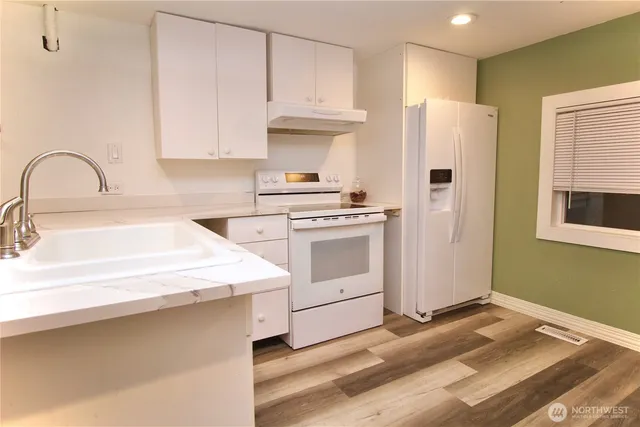 a kitchen with a stove cabinets and a refrigerator