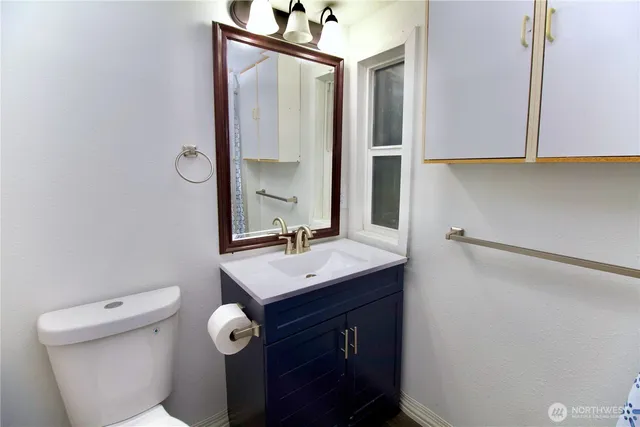 a bathroom with a toilet a sink and mirror