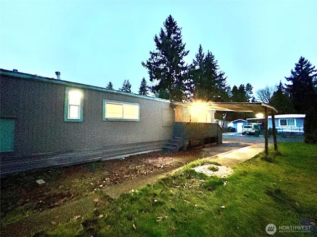 a backyard of a house with yard table and chairs