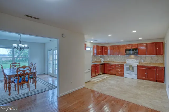 a kitchen with stainless steel appliances granite countertop a stove and a wooden floors