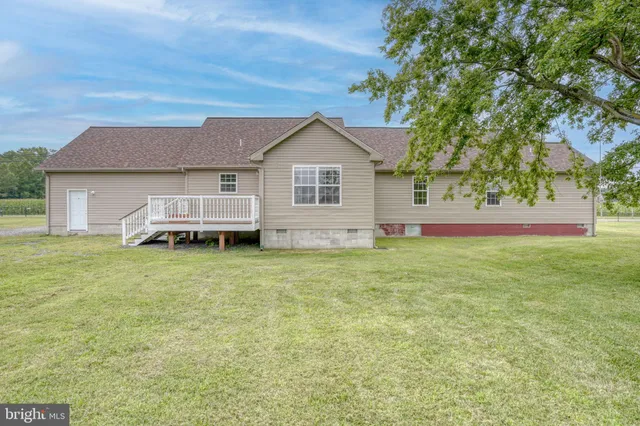 a front view of house with yard and trees in the background