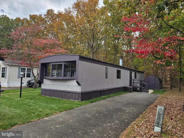 a front view of a house with a garden and trees