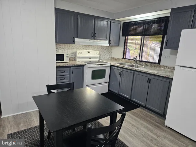 a kitchen with a table chairs microwave and cabinets