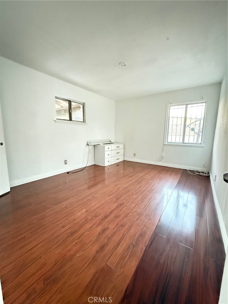 1427 South Rene Drive Santa Ana, CA 92704 - Photo 5 of 8 an empty room with wooden floor and windows