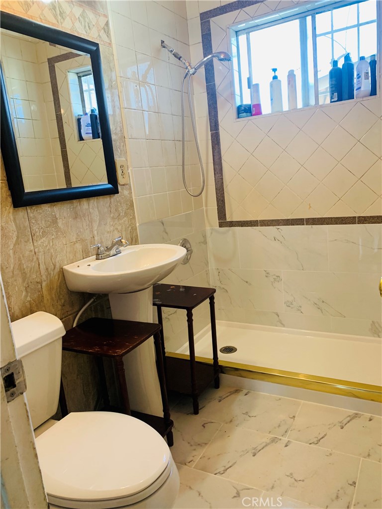 1427 South Rene Drive Santa Ana, CA 92704 - Photo 7 of 8 a bathroom with a sink a toilet and mirror