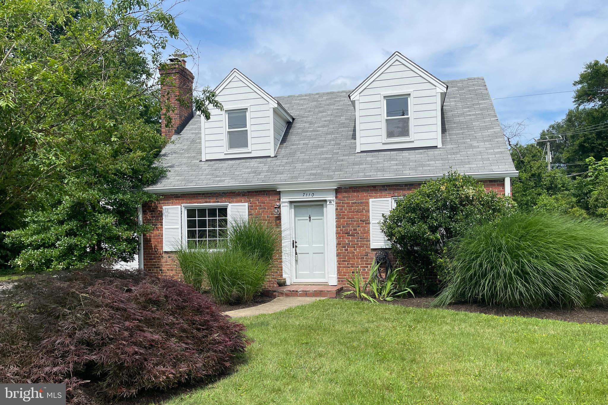 a front view of a house with a yard and trees