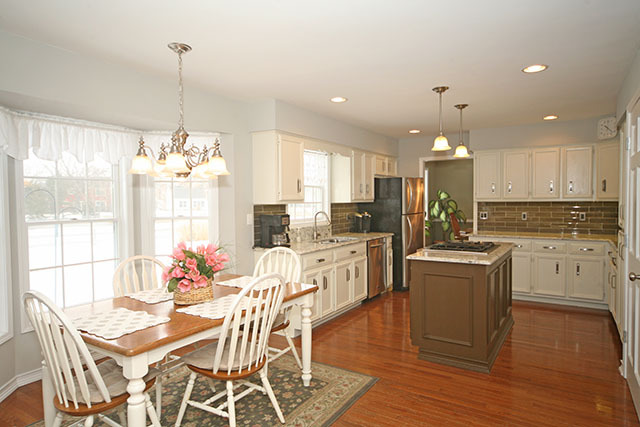 2110 Fairfax Road St. Charles, IL 60174 - Photo 9 of 20 a kitchen with stainless steel appliances kitchen island granite countertop a stove a refrigerator a kitchen island a dining table and chairs with wooden floor