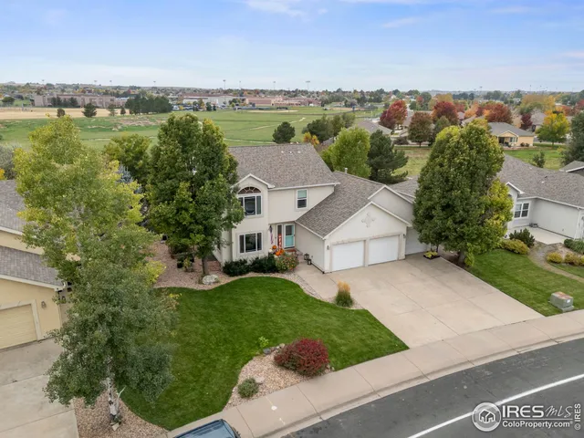 an aerial view of residential houses with outdoor space and trees