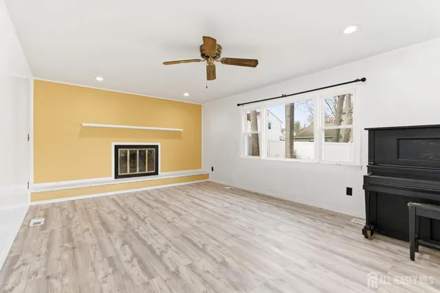 a view of an empty room with a fireplace and a window