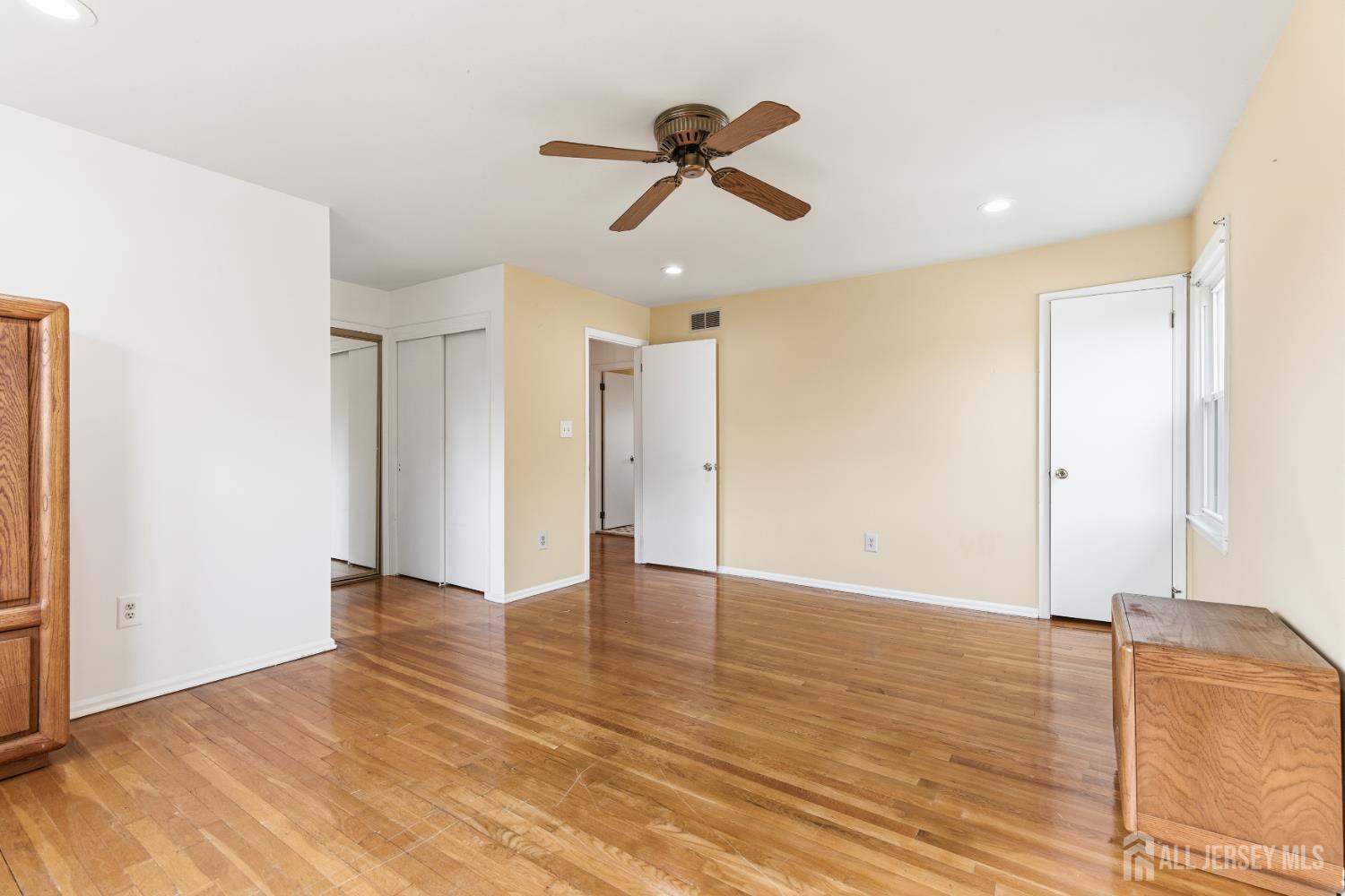 7 Oberlin Court Edison, NJ 08820 - Photo 20 of 40 a view of an empty room with wooden floor and a ceiling fan