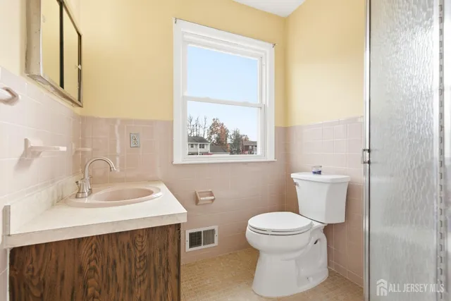 a bathroom with a sink a toilet and a mirror