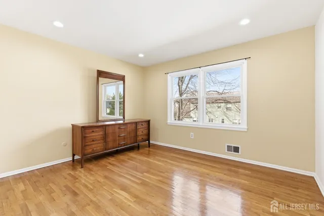 a view of room with window and wooden floor